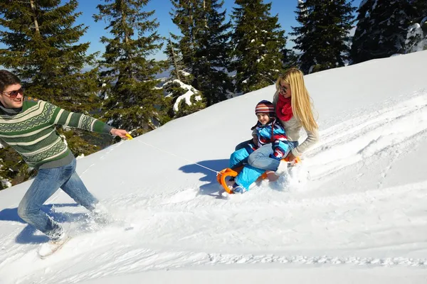 Familjen har kul på nysnö på vintern — Stockfoto