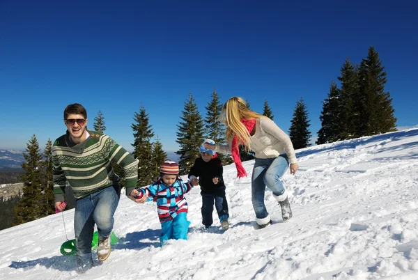 Familjen ha roligt på nysnö på vintersemester — Stockfoto