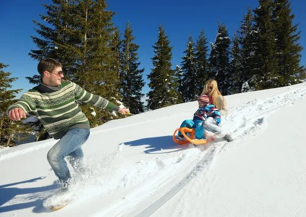 Familia divirtiéndose en nieve fresca en las vacaciones de invierno —  Fotos de Stock