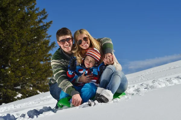 Familia divirtiéndose en nieve fresca en las vacaciones de invierno Imagen De Stock