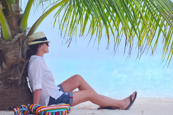 Vacker flicka under palmerna på stranden — Stockfoto
