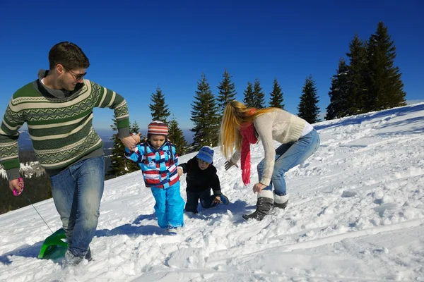 Family having fun on fresh snow at winter vacation — Stock Photo, Image