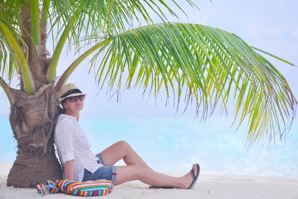 Gyönyörű lány a strandon a palm fa alatt — Stock Fotó