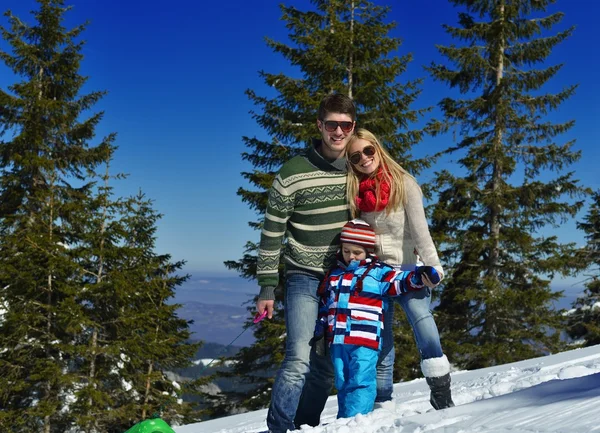Familia divirtiéndose en nieve fresca en las vacaciones de invierno —  Fotos de Stock