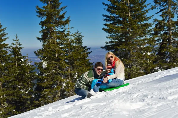 Familia divirtiéndose en nieve fresca en las vacaciones de invierno — Foto de Stock