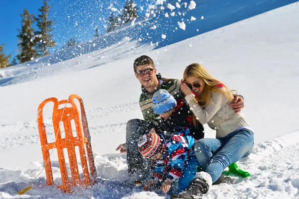 Familia divirtiéndose en nieve fresca en las vacaciones de invierno — Foto de Stock