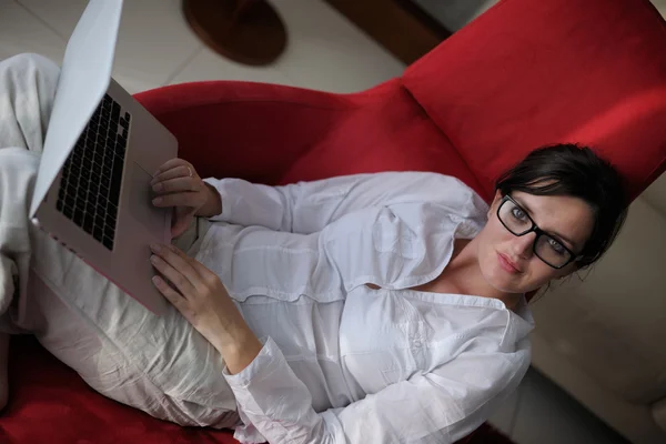 Mulher usando um computador portátil em casa — Fotografia de Stock