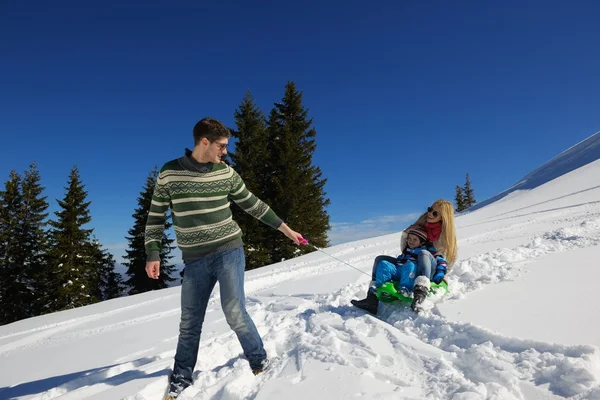 Família se divertindo na neve fresca nas férias de inverno — Fotografia de Stock