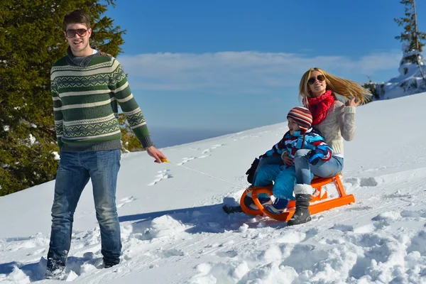 Familia divirtiéndose en nieve fresca en las vacaciones de invierno — Foto de Stock