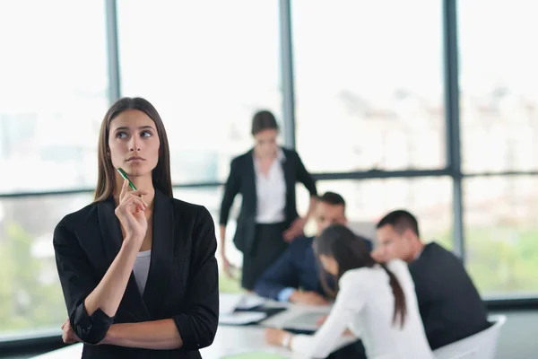 Zakenvrouw met haar personeel op achtergrond op kantoor — Stockfoto