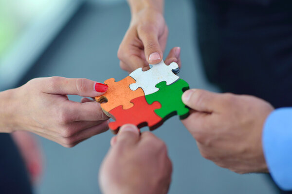 Group of business people assembling jigsaw puzzle