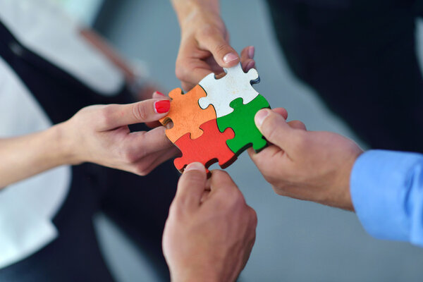 Group of business people assembling jigsaw puzzle