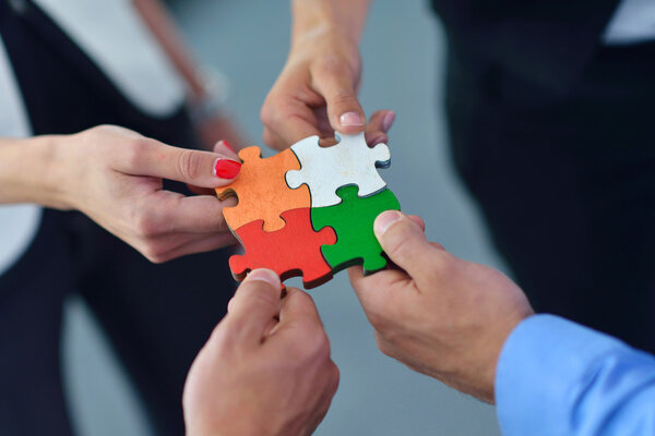 Group of business people assembling jigsaw puzzle