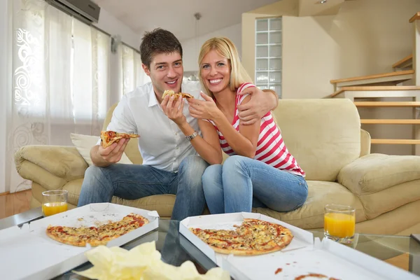 Coppia a casa mangiare pizza — Foto Stock