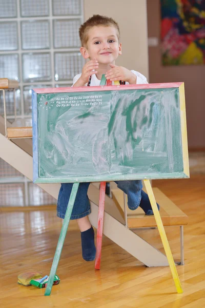 Menino desenho no conselho escolar em casa — Fotografia de Stock