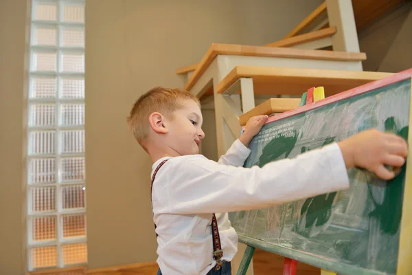 Junge zeichnet zu Hause auf Schultafel — Stockfoto