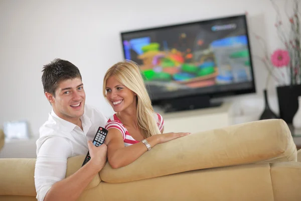 Relaxé jeune couple regarder la télévision à la maison — Photo