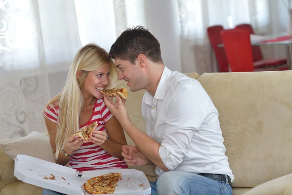 Casal em casa comer pizza Fotografias De Stock Royalty-Free