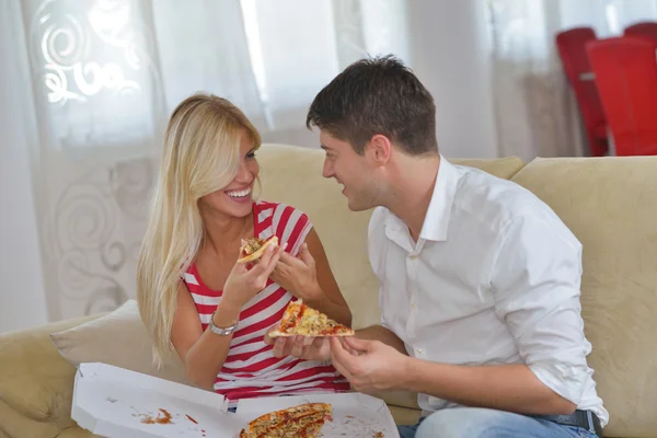 Paar thuis eten van pizza Stockfoto