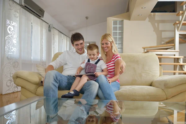 Семья дома с помощью планшетного компьютера — стоковое фото