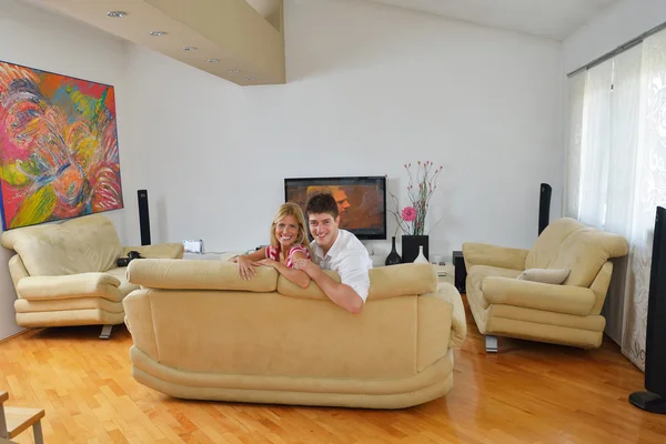 Расслабленная молодая пара смотрит телевизор дома — стоковое фото