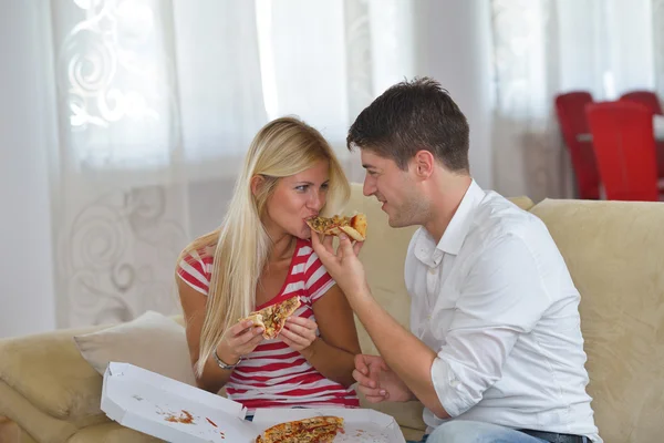 Пара дома едят пиццу — стоковое фото