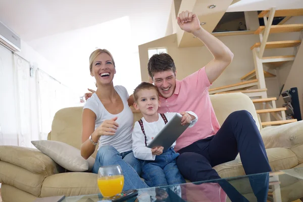 Семья дома с помощью планшетного компьютера — стоковое фото