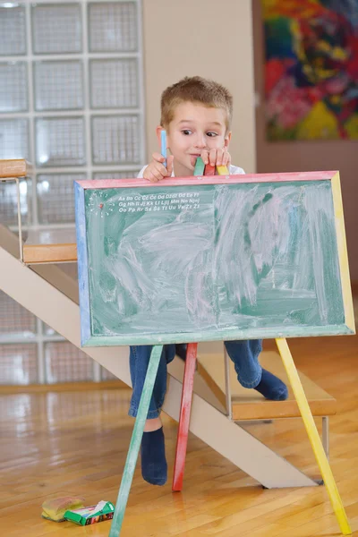 Menino desenho no conselho escolar em casa — Fotografia de Stock