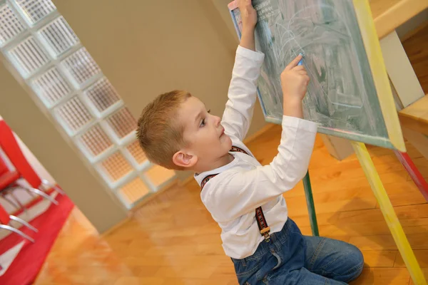 Мальчик рисует на школьной доске дома — стоковое фото