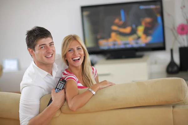 Relaxed young couple watching tv at home Stock Picture