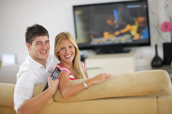 Relaxado jovem casal assistindo tv em casa — Fotografia de Stock