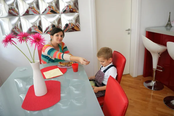 Mutter füttert ihren Sohn mit Pizza — Stockfoto