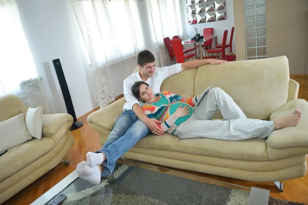 Pregnant couple at home using tablet computer — Stock Photo, Image