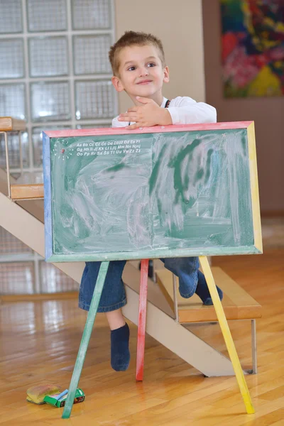 Menino desenho no conselho escolar em casa — Fotografia de Stock