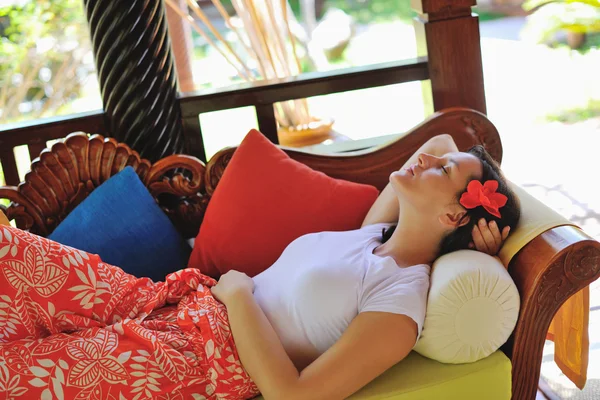 Žena odpočívá na gauči, tropický resort — Stock fotografie