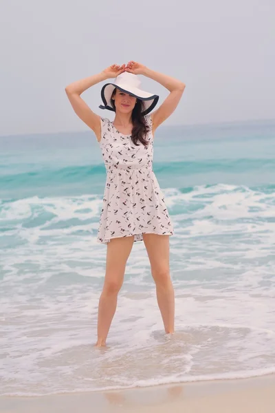 Vrouw met hoed op strand — Stockfoto