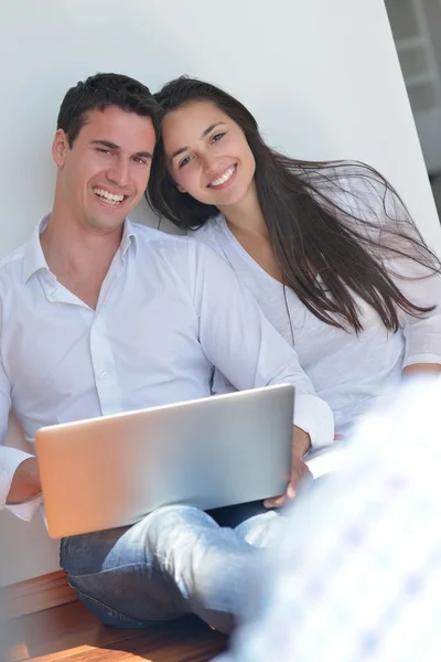 Pareja usando el ordenador portátil en casa — Foto de Stock