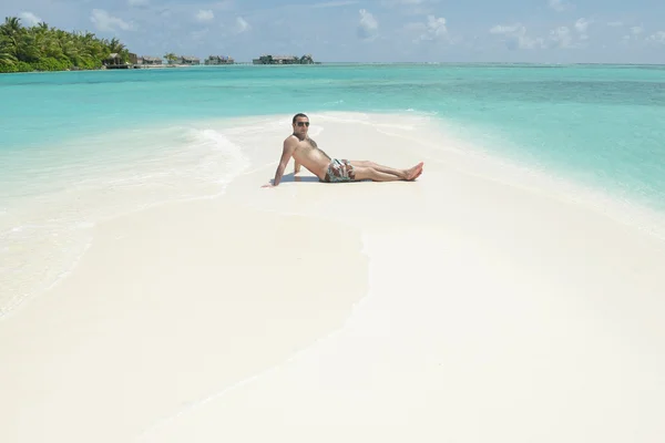 Man sitter på stranden — Stockfoto