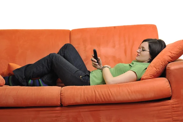 Feliz joven mujer relajarse en sofá naranja — Foto de Stock