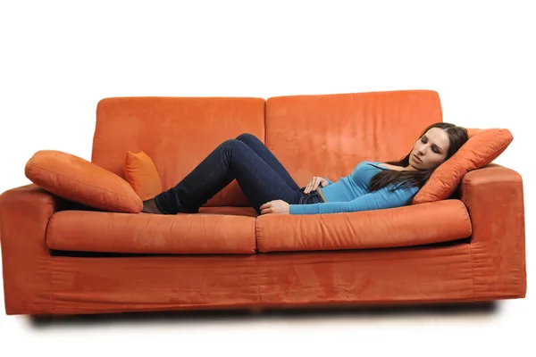 Nő a narancssárga kanapé pihenni — Stock Fotó