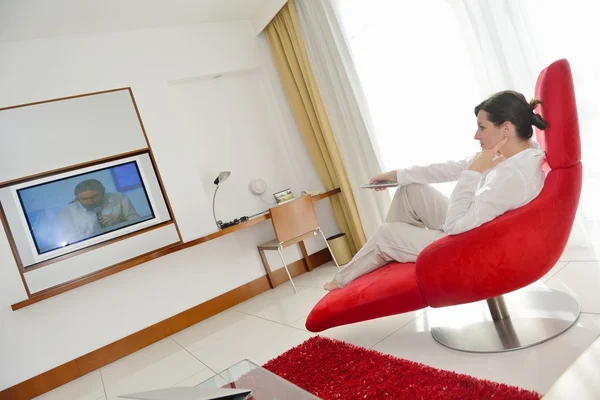 Jovem mulher assistindo TV em casa — Fotografia de Stock