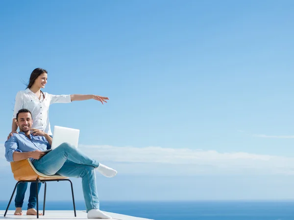 Relaxed young couple working on laptop computer at home — Stock Photo, Image