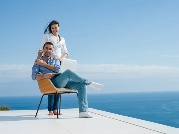 Relaxado jovem casal trabalhando no computador portátil em casa — Fotografia de Stock