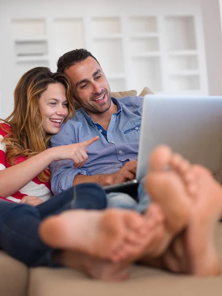 Relaxado jovem casal trabalhando no computador portátil em casa — Fotografia de Stock