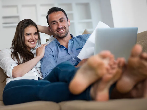 Ontspannen jonge paar werken op laptopcomputer thuis — Stockfoto