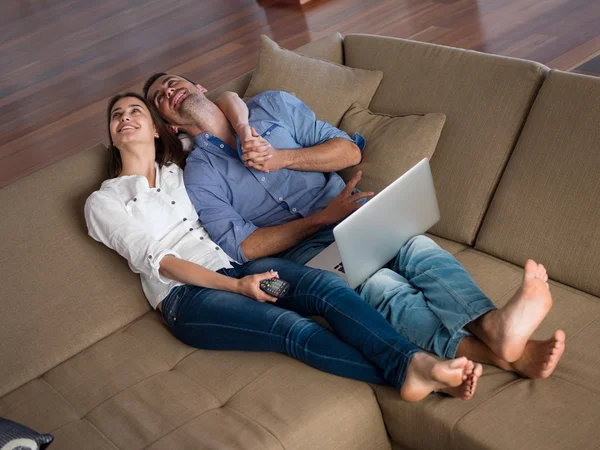 Ontspannen jonge paar werken op laptopcomputer thuis — Stockfoto