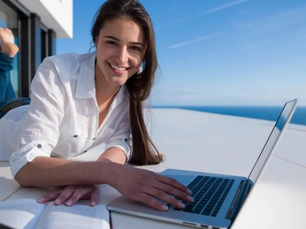 Entspannte junge Frau arbeitet zu Hause am Laptop — Stockfoto