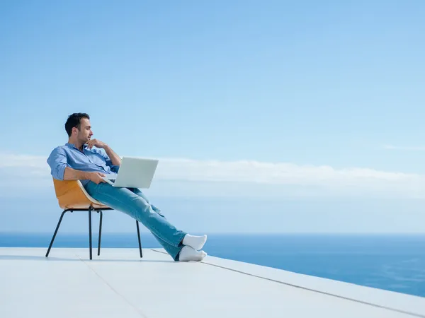 Entspannter junger Mann zu Hause auf Balkon Stockfoto