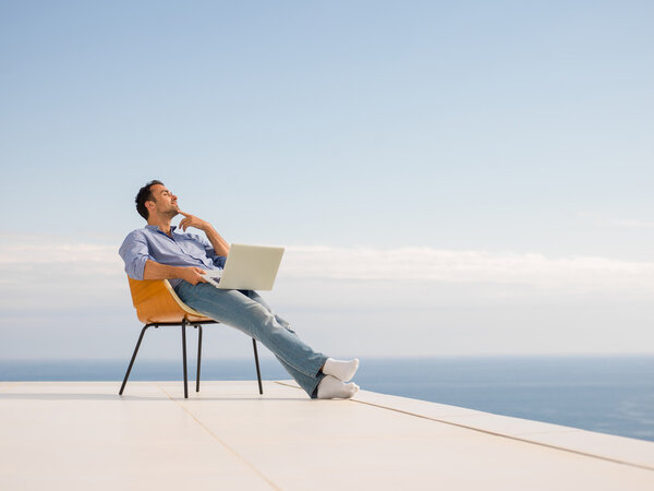 расслабленный молодой человек дома на балконе