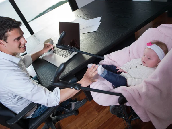 Werken vanuit huis man en verzorgen van baby — Stockfoto